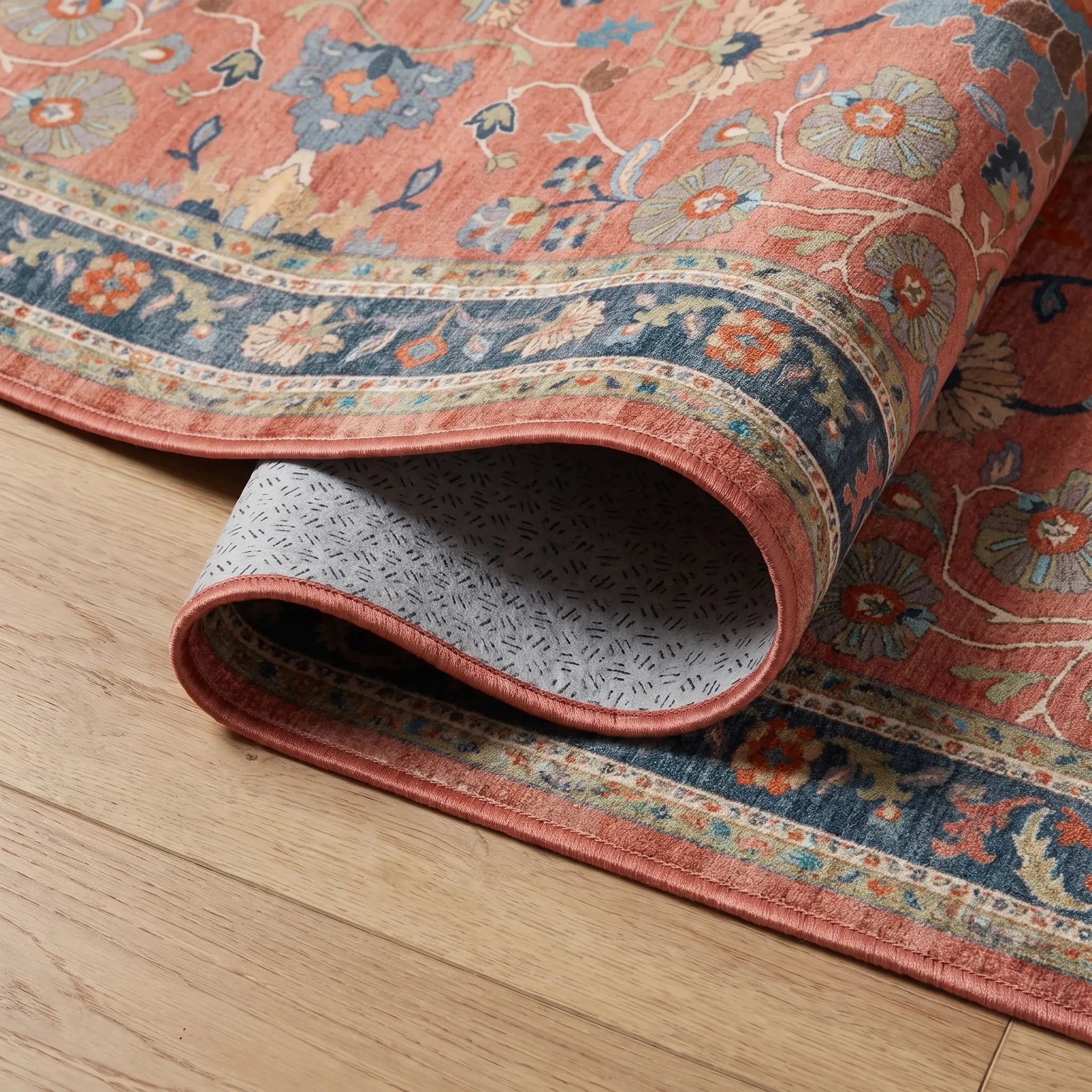 Calabria Coral Multicolor Rug corner folded back showing the bound edge and non slip backing