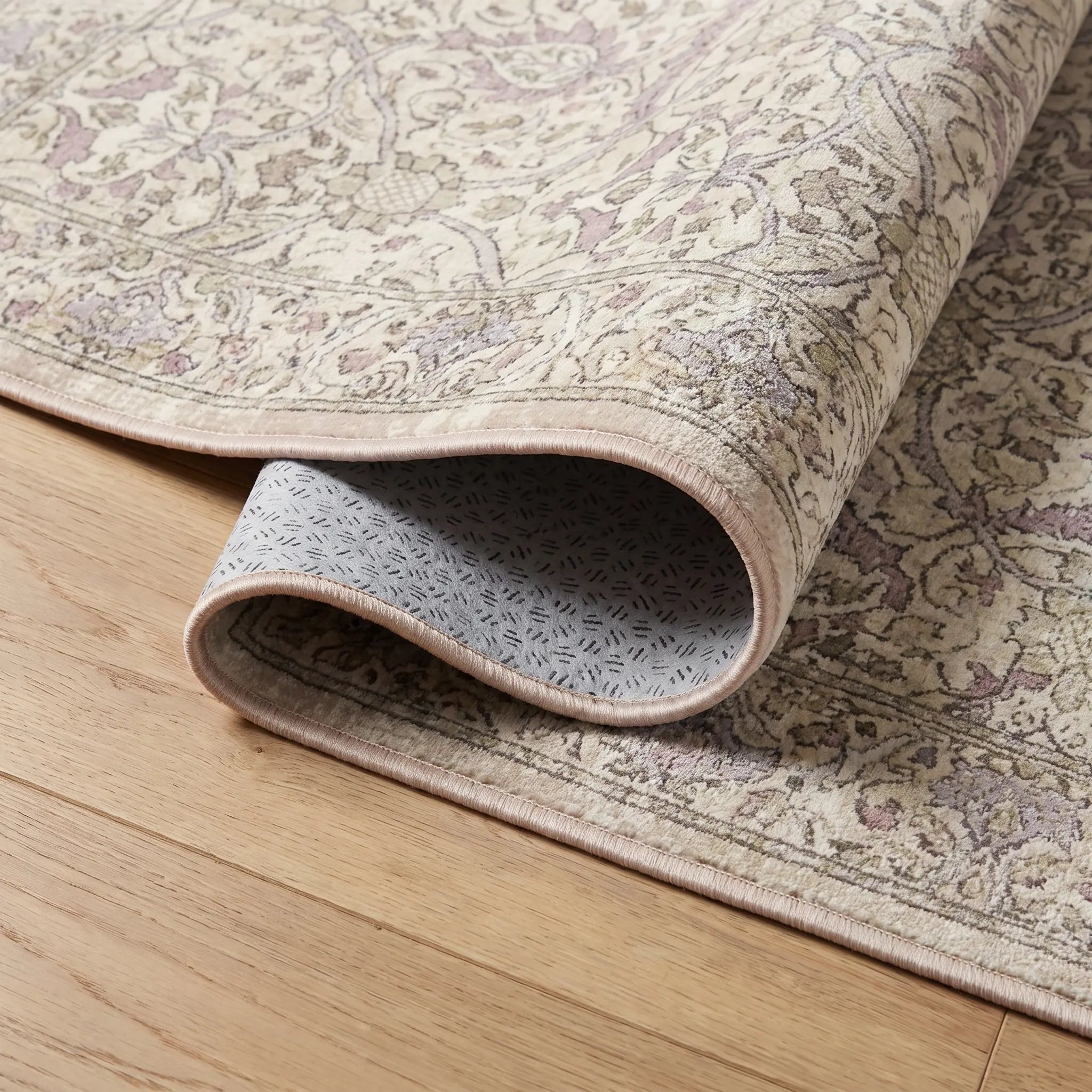 Montreal Beige and Lilac Rug corner folded back showing the bound edge and non slip backing